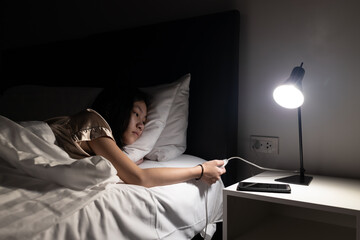 Asian child girl resting on the bed,turning off the light switch before bedtime to sleep in the...
