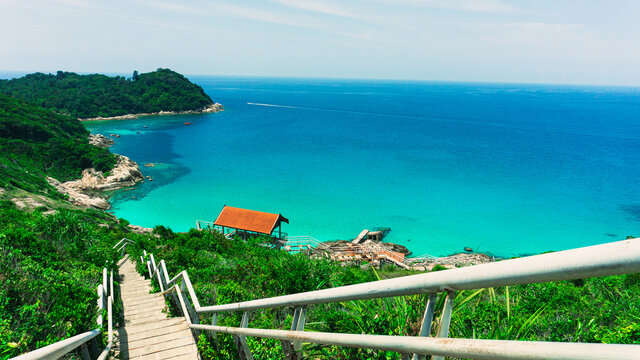 The beautiful scenic view of Small Perhentian Island in Terengganu, Malaysia. The wide view of ocean and green island from the peak of hill. The concrete stairs lead the way to the abandoned jetty.