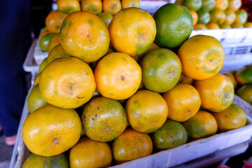 A close-up of an arrangement of mandarin oranges at a traditional fruit shop in Indonesia