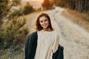 smiling Woman in white sweater with jacket outdoors autumn sunny day