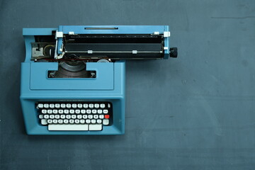 Fototapeta na wymiar macchina da scrivere su lasstra di ardesia con gessetti e scritte (amore, amici, mare) e spazio per scrittura