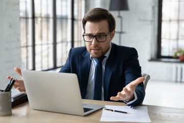 Displeased stressed young 30s businessman entrepreneur ceo manager confused with received bank loan...