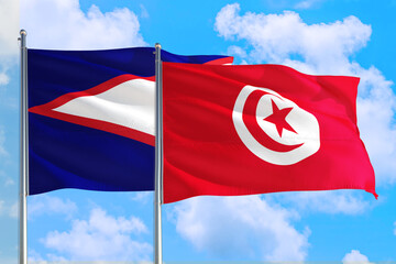 Tunisia and American Samoa national flag waving in the windy deep blue sky. Diplomacy and international relations concept.