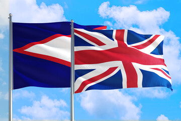 United Kingdom and American Samoa national flag waving in the windy deep blue sky. Diplomacy and international relations concept.