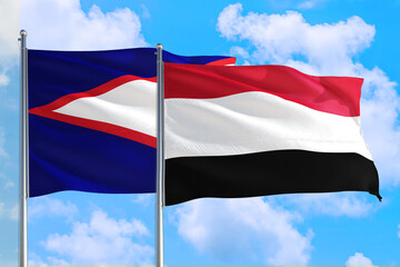 Yemen and American Samoa national flag waving in the windy deep blue sky. Diplomacy and international relations concept.