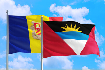 Antigua and Barbuda and Andorra national flag waving in the windy deep blue sky. Diplomacy and international relations concept.