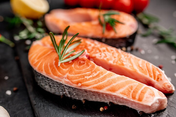 raw salmon steak with spices on a stone background