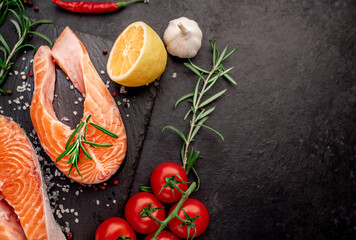 raw salmon steak with spices on a stone background with copy space for your text	