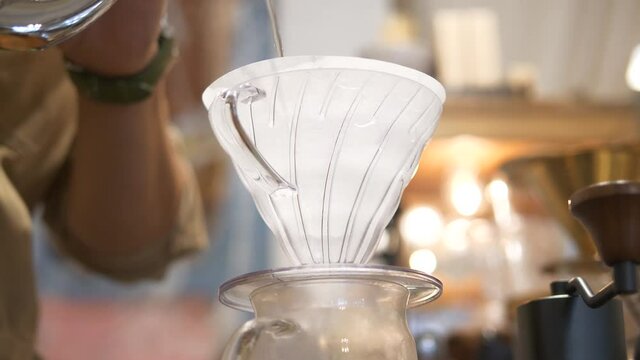 Pouring hot water into coffee dripper for hand brew &mdash; slow life, barista craft, and minimalist coffee brewing concept