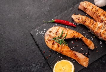 Grilled salmon steaks with spices on stone background with copy space for your text	