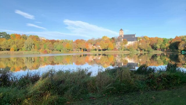 Video panning over the lake that is part of the Chemnitz Castle Park. In the background the Chemnitz Castle and the Main Energy Power Plant Tower.