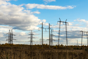 Rusty and black power line is on the blue sky with white clouds background