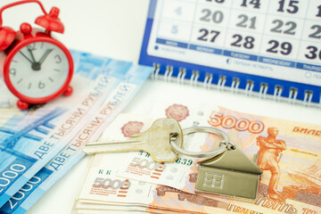 Russian money, an alarm clock and a key to the apartment in the background of the calendar