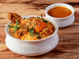Traditional Hyderabadi Chicken dum Biryani made of Basmati rice cooked with masala spices, served with Salan, selective focus