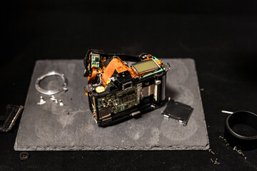 The stuffing of an old camera. All internals of the camera without external protective case on a tray in dark tones