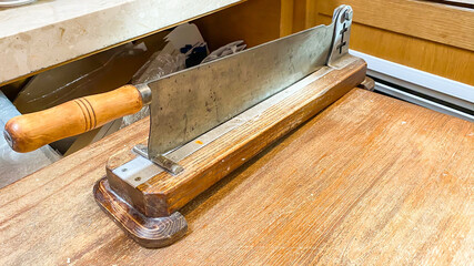 Large long knife screwed to a wooden table in a pastry shop