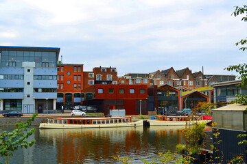Obraz premium Amstel river, boats and modern architecture in Amsterdam city, The Netherlands. 