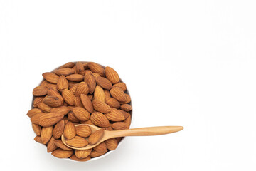 Almond nuts in white bowl with wooden spoon on isolate white background,vegetarian food,top view,flat lay,top down,selective focus.