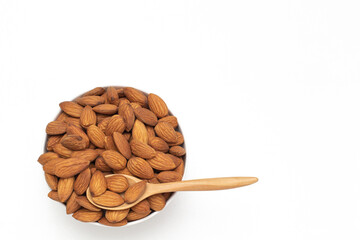 Fototapeta na wymiar Almond nuts in white bowl with wooden spoon on isolate white background,vegetarian food,top view,flat lay,top down,selective focus.