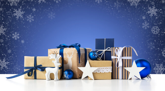 Gift boxes and christmas blue balls on winter abstract background