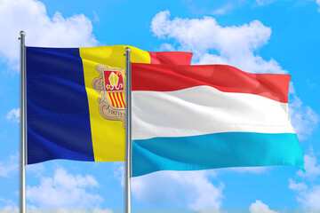 Luxembourg and Andorra national flag waving in the windy deep blue sky. Diplomacy and international relations concept.