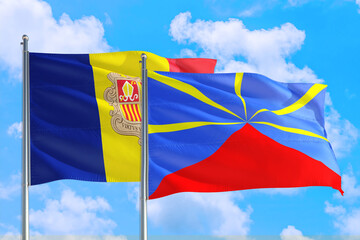Reunion and Andorra national flag waving in the windy deep blue sky. Diplomacy and international relations concept.
