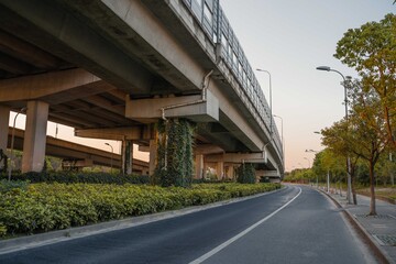 Obraz premium Urban road under overpass bridge at sunset.