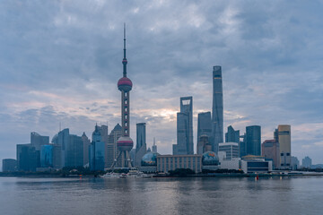 Naklejka premium Sunrise view of Lujiazui, the financial district in Shanghai, China, on a cloudy day.