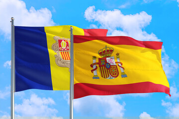 Spain and Andorra national flag waving in the windy deep blue sky. Diplomacy and international relations concept.