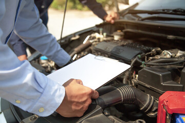 Auto mechanic using checklist for car engine systems after fixed. Concepts of car fix and checking repair and service maintenance.