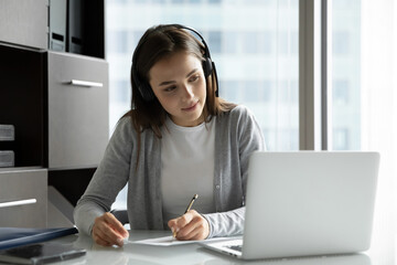 Work and study. Interested millennial woman employee trainee intern sitting at desk wearing...