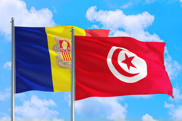 Tunisia and Andorra national flag waving in the windy deep blue sky. Diplomacy and international relations concept.