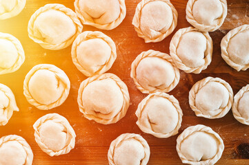 pile of small homemade uncooked dumplings with meat on kitchen table. national traditional Russian cuisine. do it yourself. top view, flat lay