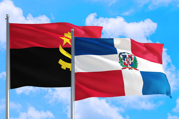 Dominican Republic and Angola national flag waving in the windy deep blue sky. Diplomacy and international relations concept.