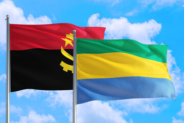Gabon and Angola national flag waving in the windy deep blue sky. Diplomacy and international...