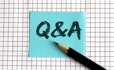 Q AND A , the phrase is written on colored stickers, on a notepad background. Business concept