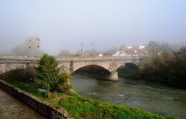 Naklejka premium an old stone bridge on a foggy morning