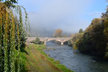 Fototapeta na wymiar an old stone bridge on a foggy morning
