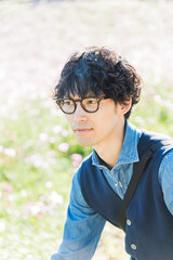 コスモス畑で微笑む若い男性