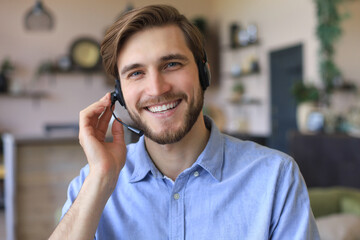Male customer support operator with headset and smiling.