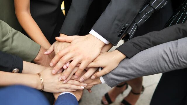 Unity and teamwork. Group of Businesspeople putting their hands together.