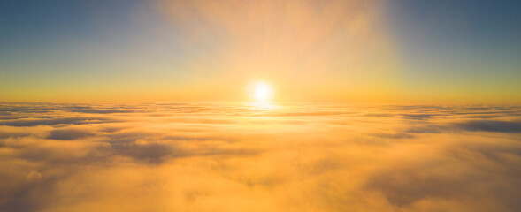 Obraz premium Morning Rising Sun in haze over fog - panorama made by a high-flying drone