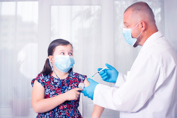 Vaccination concept. Male doctor vaccinating cute little girl in clinic.