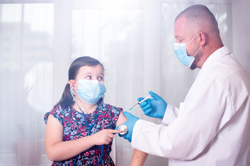 Vaccination concept. Male doctor vaccinating cute little girl in clinic.