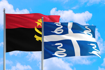 Martinique and Angola national flag waving in the windy deep blue sky. Diplomacy and international relations concept.
