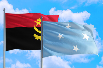Micronesia and Angola national flag waving in the windy deep blue sky. Diplomacy and international relations concept.