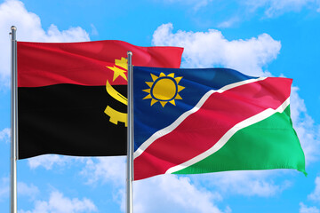 Namibia and Angola national flag waving in the windy deep blue sky. Diplomacy and international relations concept.