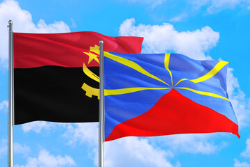 Reunion and Angola national flag waving in the windy deep blue sky. Diplomacy and international relations concept.