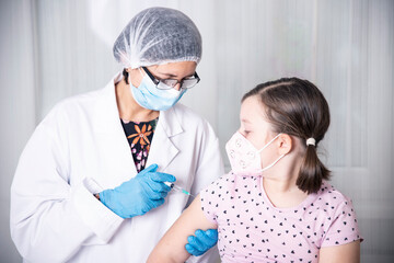 Vaccination concept. Female doctor vaccinating cute little girl in clinic.