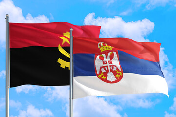 Serbia and Angola national flag waving in the windy deep blue sky. Diplomacy and international relations concept.